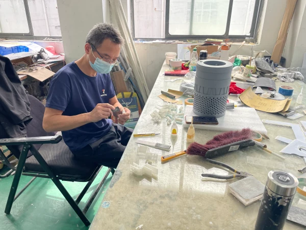 Craftsman assembling custom new energy scale model in workshop